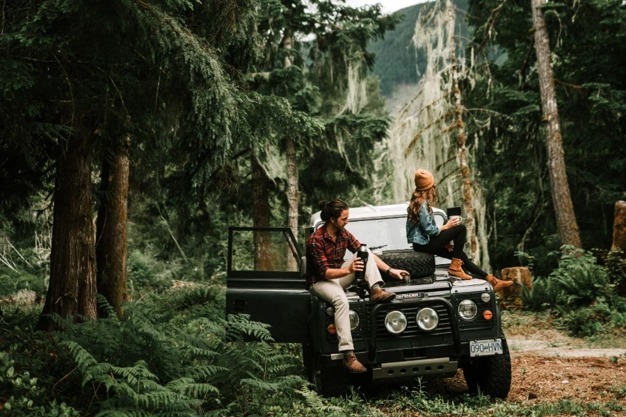 man and woman sitting on black jeep wrangler