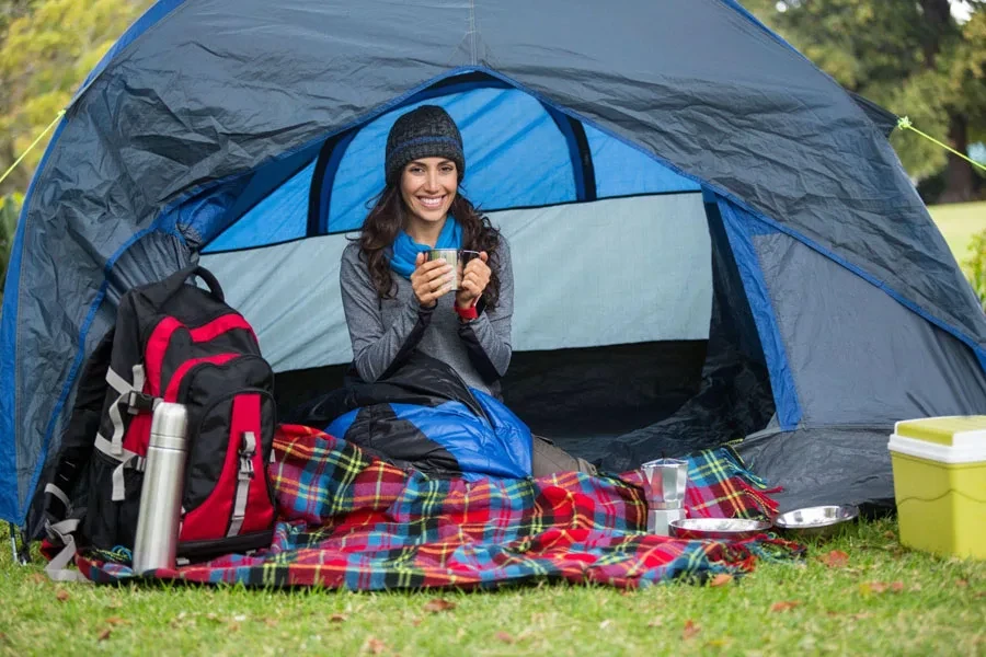 smiling hiker having cup of coffee