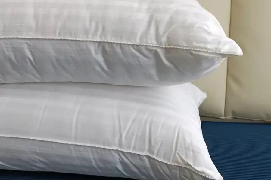 Dos interiores de almohadas de algodón densamente acolchados sobre fondo azul.