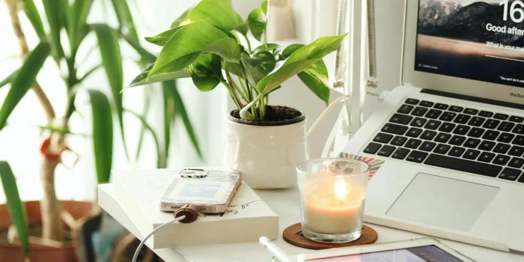 work space with candle and charging phone on desk