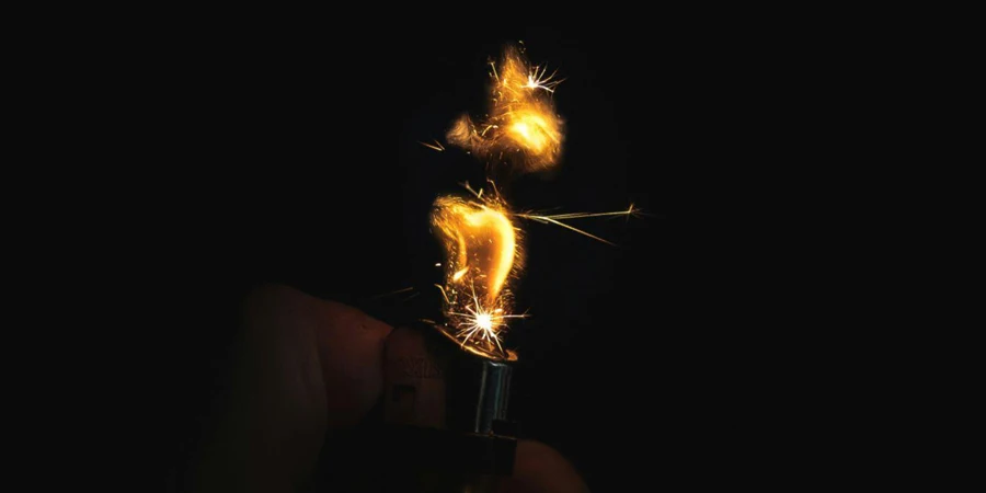 A Hand Holding a Lighter With Sparks Coming Out of It