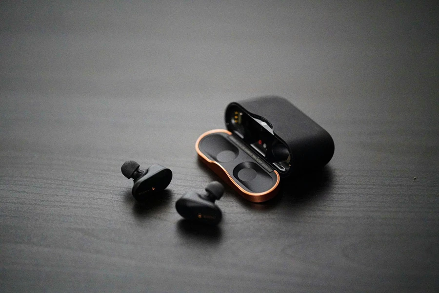 A Pair of Black and Gold Ear Bud on a Table
