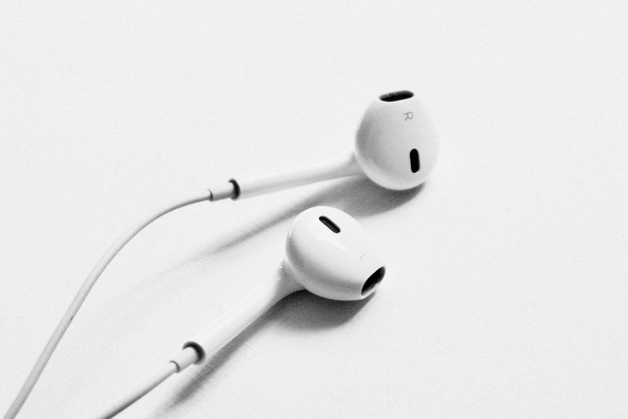 A Pair of White Earphones Placed on a White Surface