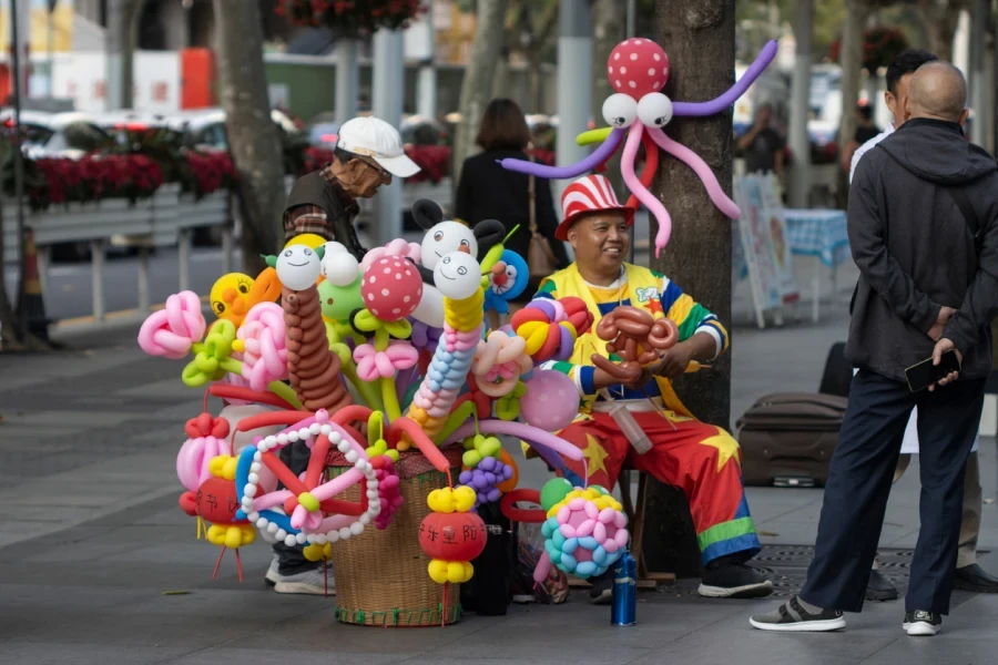 Un artista di palloncini per le strade del quartiere Jing'an di Shanghai durante il Festival di Chongyang a Shanghai, Cina