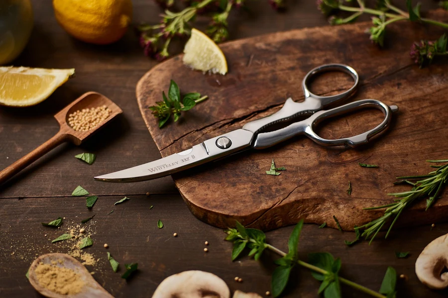 Uma tesoura de cozinha em uma tábua de cortar