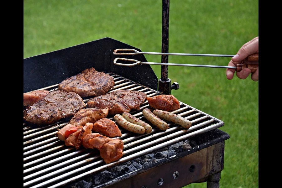 A person cooking food on a hot grill