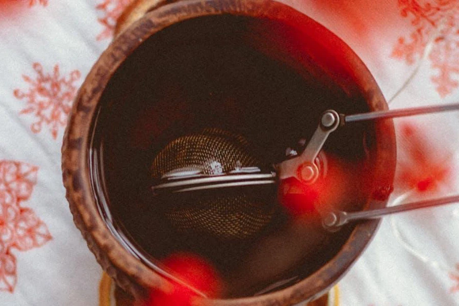 A tea infuser dipped into a cup