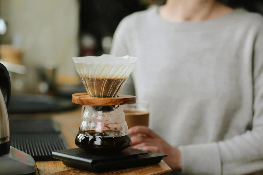 Eine junge Dame brüht Kaffee mit einem Filter