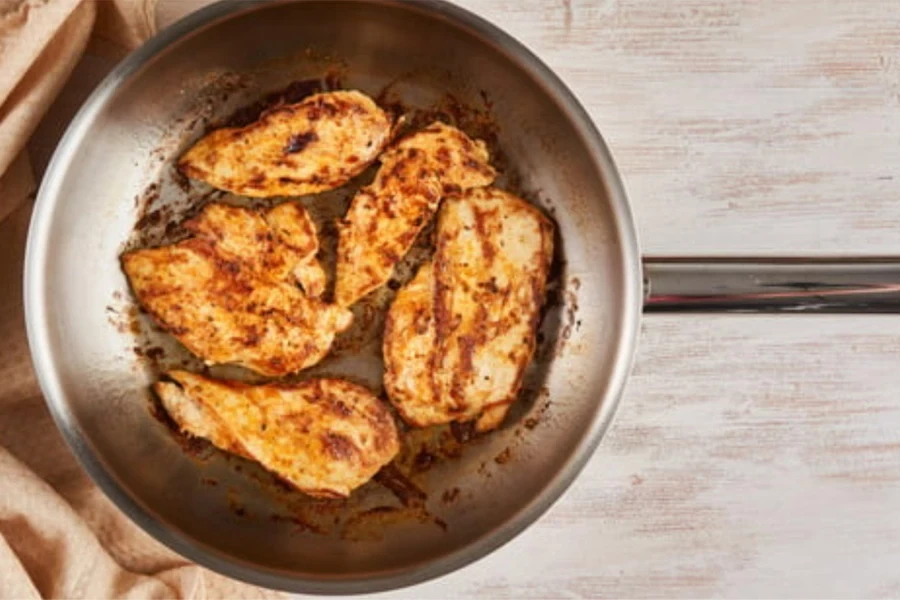 Una cacerola de aluminio con pollo al vapor.