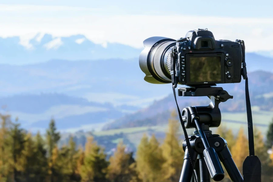 Câmera DSLR preta montada em tripé preto