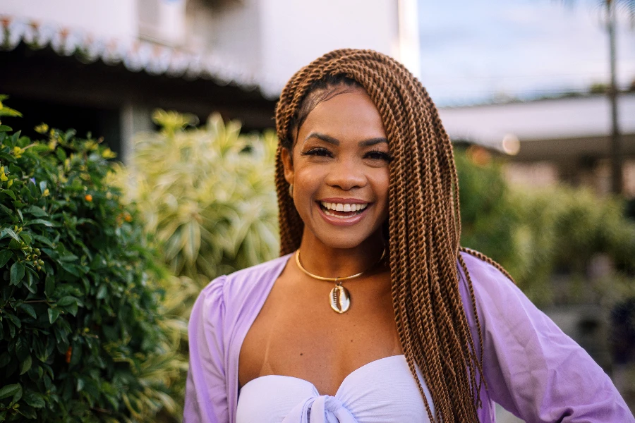 Black woman wearing braids smiling outdoors