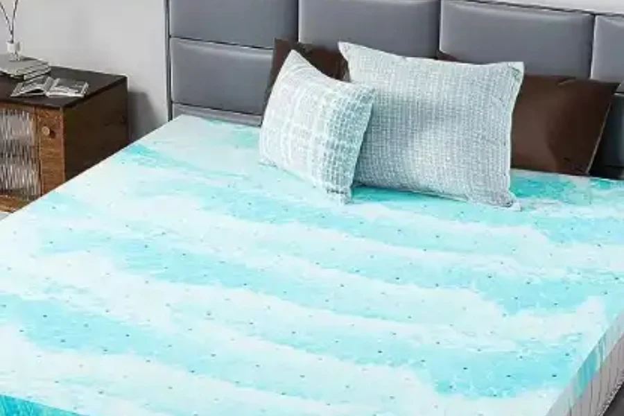 Cubrecolchón de espuma viscoelástica de gel azul y blanco en la cama