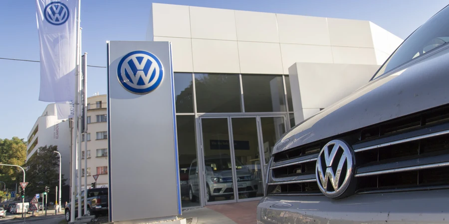 Voiture avec logo Volkswagen devant le concessionnaire
