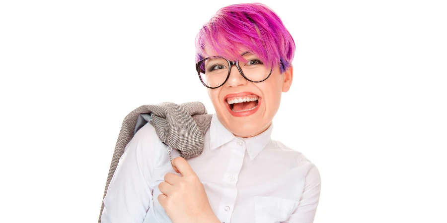 Cheerful stylish millennial woman in glasses holding jacket on shoulder
