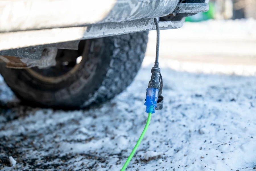 Closeup of extension cord plugged into truck on cold day