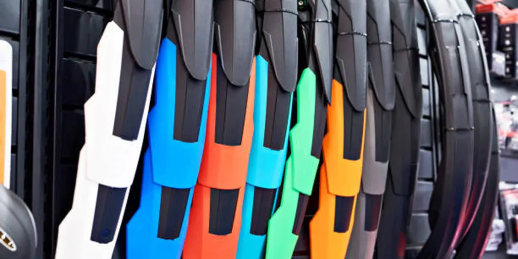 Different colors of bicycle fenders hanging on wall display
