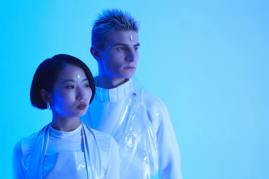 Foto futuristica di un giovane uomo e di una donna in piedi sotto l'illuminazione blu