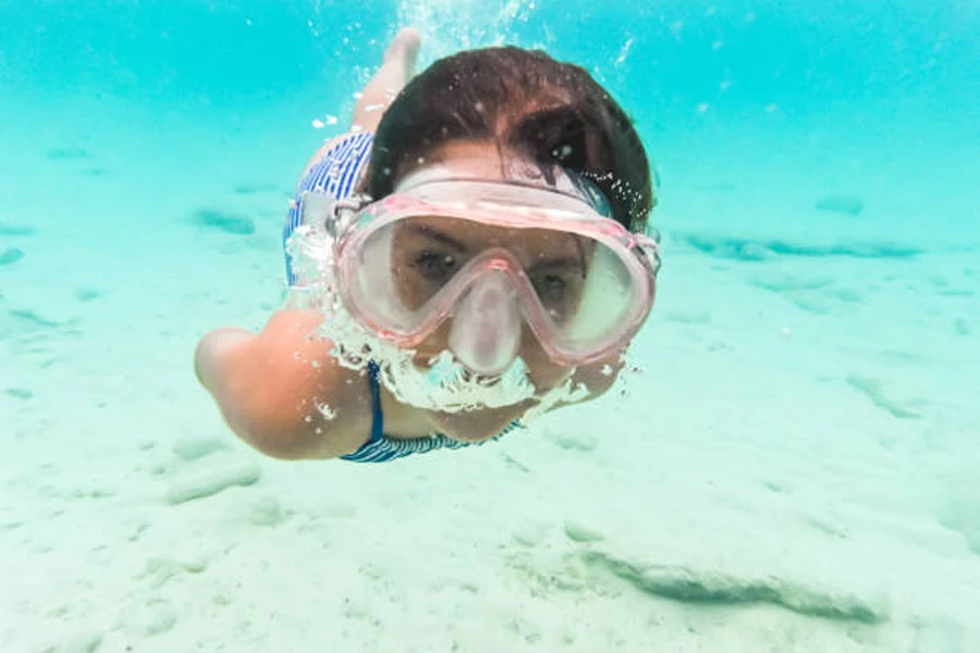 Buğu önleyici şnorkel maskesiyle su altında şnorkelli dalış yapan kız
