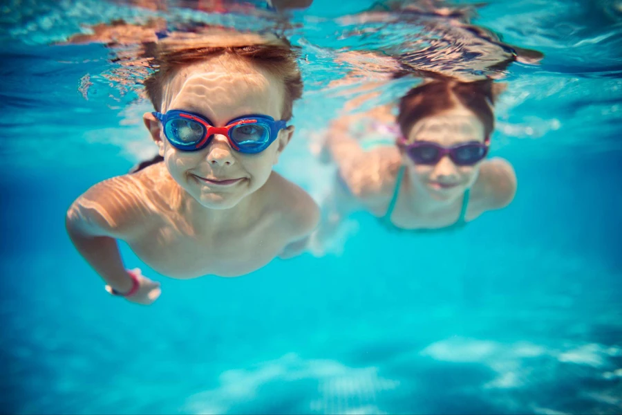Enfants heureux nageant sous l’eau dans la piscine