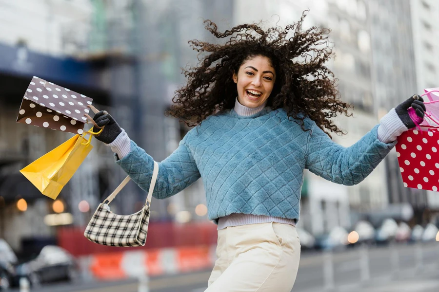 امرأة سعيدة تقفز مع أكياس التسوق