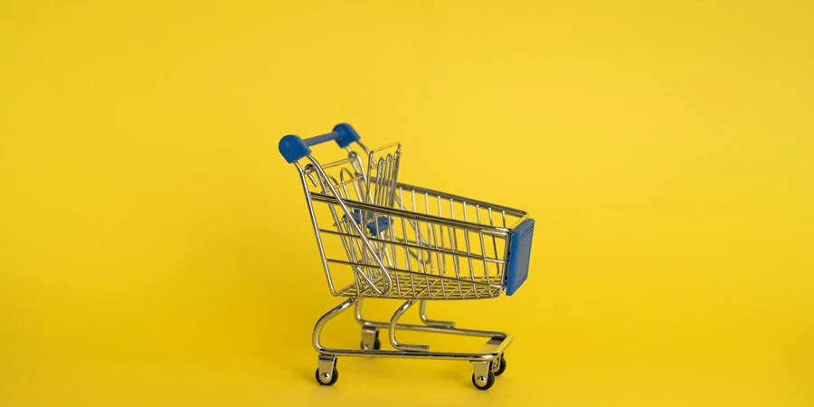 Isolierter Einkaufswagen aus glänzendem Metall ohne etwas Separates auf gelbem Hintergrund