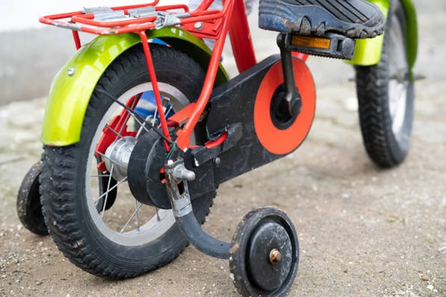 Kinderfahrrad mit Stützrädern und gelben Fahrradschutzblechen