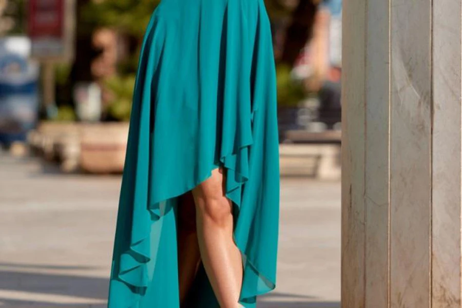 Açık havada yeşil asimetrik bir sundress giyen bayan