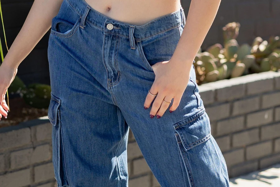 Wanita berpose dengan jeans kargo bertingkat rendah