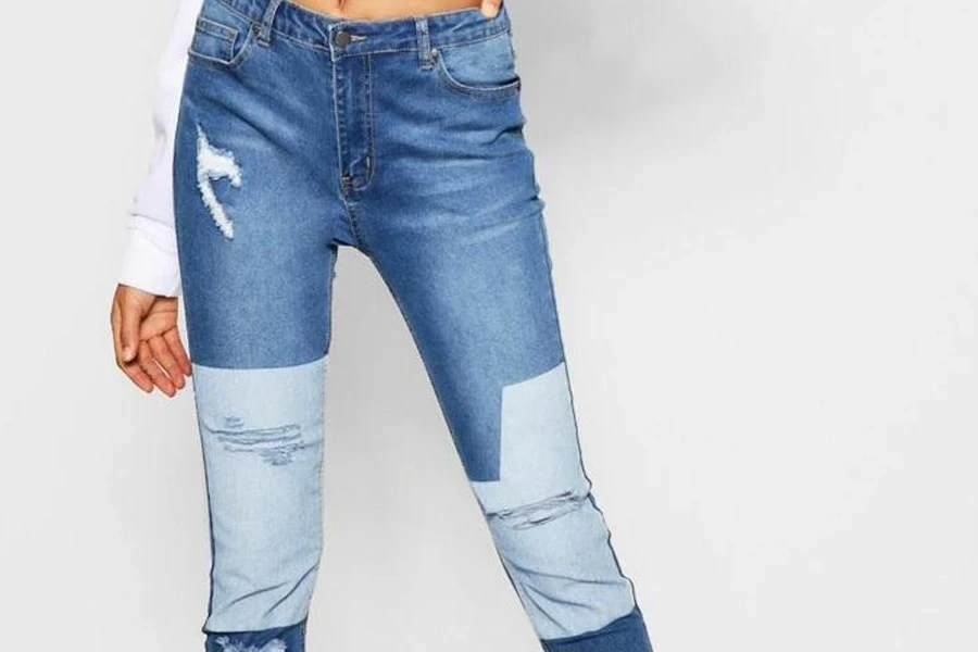 Dame trägt ein Paar zweifarbige Low-Rise-Jeans