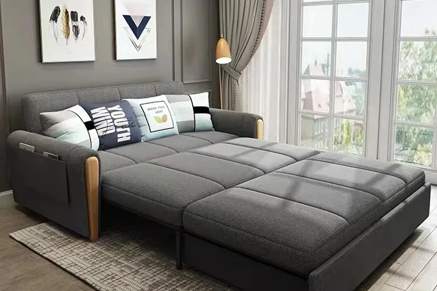 Большой серый раскладной диван-кровать с местом для хранения вещей.
