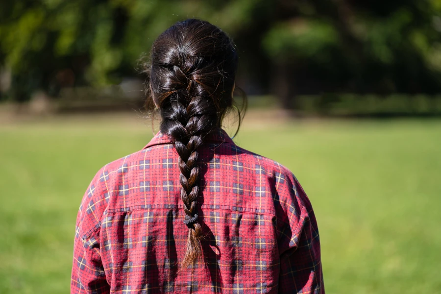 Латинская женщина сзади с косой в парке