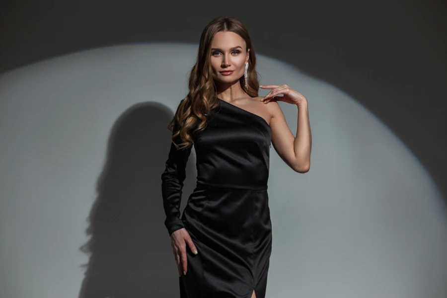 Schöne schöne glamouröse schicke Frau mit einem Diamantohrring in einem eleganten schwarzen stilvollen Abendkleid