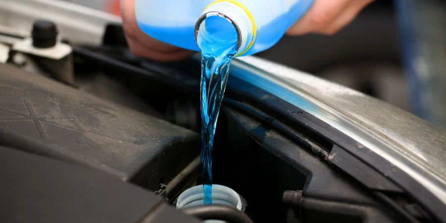 Male hands hold bottle of blue antifreeze in their hands