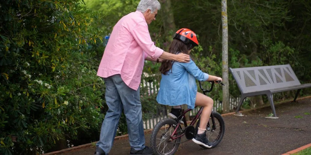 Un uomo aiuta un bambino a imparare ad andare in bicicletta