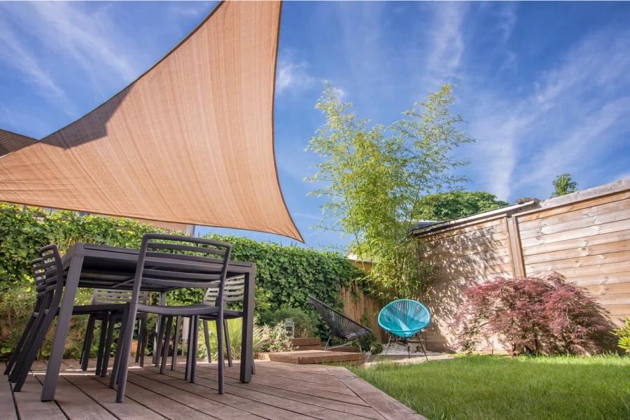 Terrazza moderna della casa in estate con tavolo e vela ombreggiante