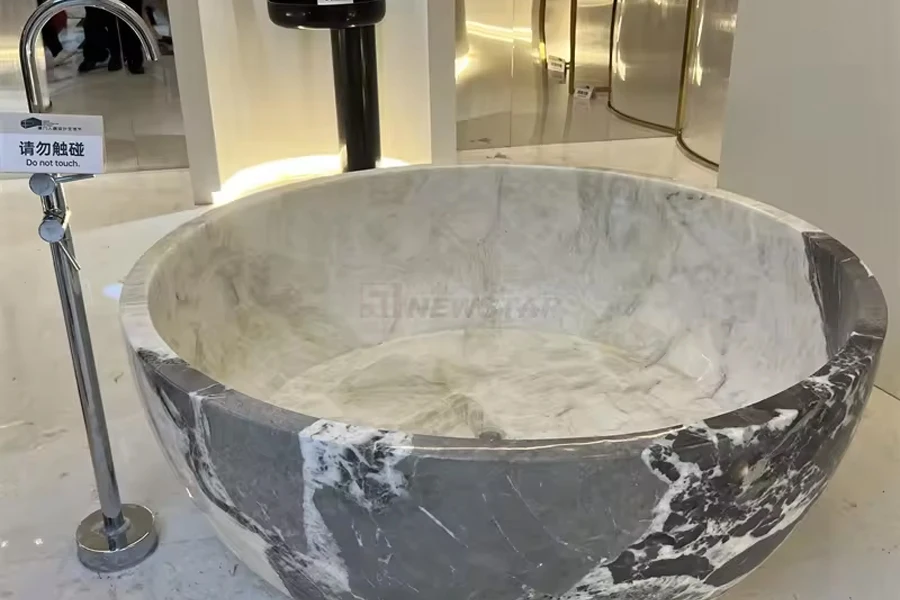 Bañera redonda moderna de mármol gris y blanco.