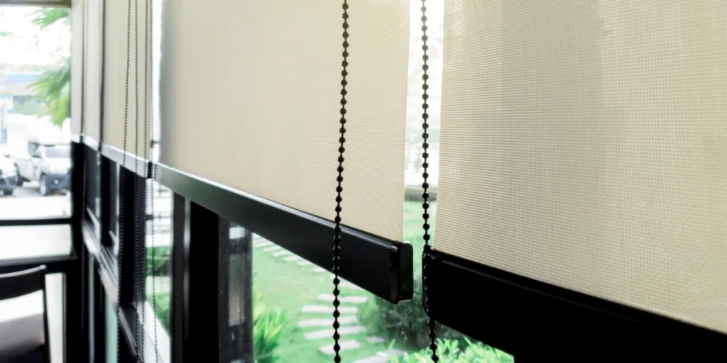Partially drawn roller blinds on a transparent window frame