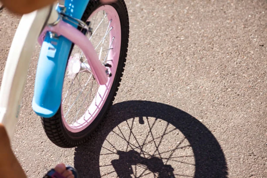 دراجة باللونين الوردي والأبيض مع مصدات دراجة باللون الأزرق الفاتح
