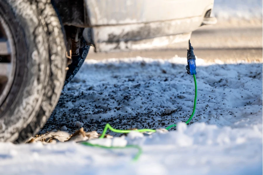 Side view of extension cord plugged into truck on cold day