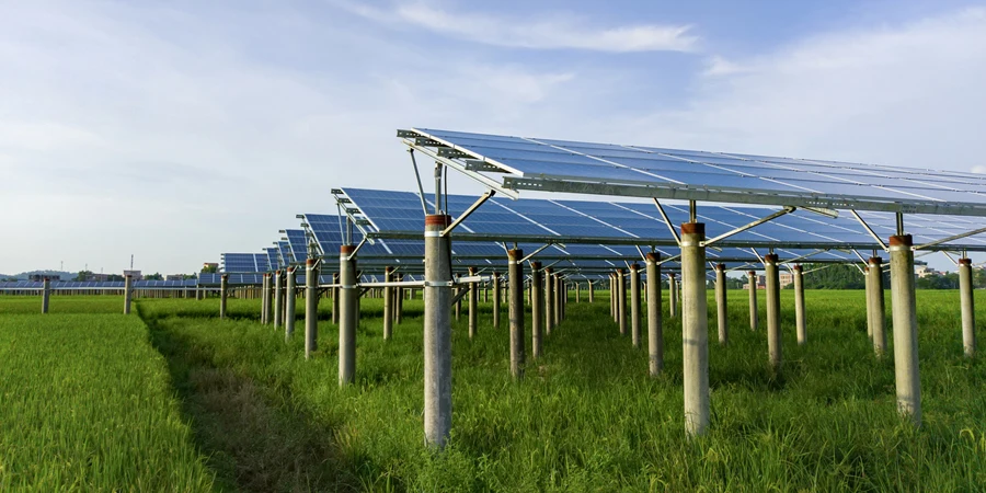 Generación de energía solar en campos de arroz bajo un cielo azul y nubes blancas