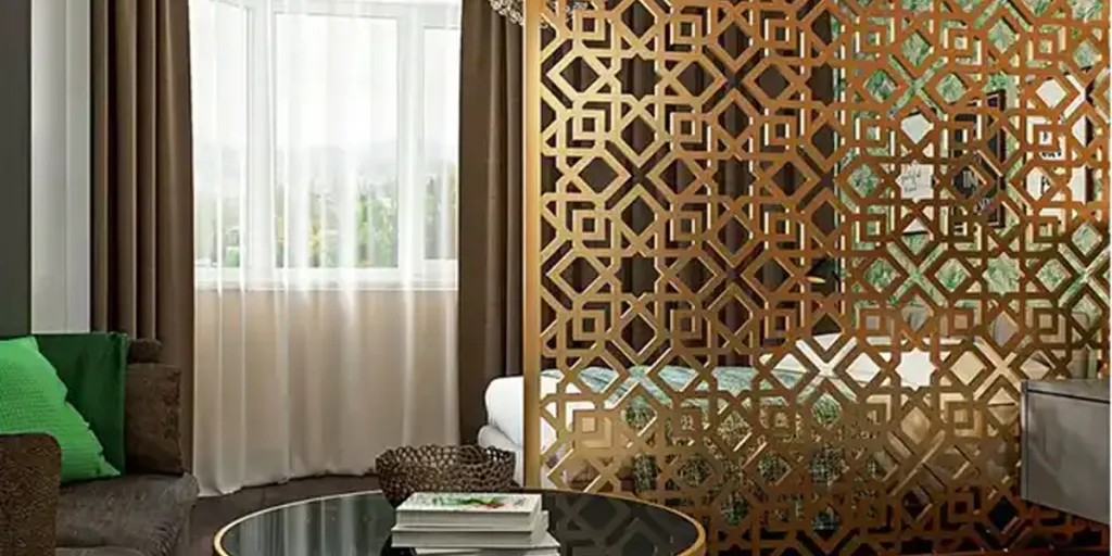 Mampara decorativa de acero inoxidable que separa las zonas de dormitorio y de estar.