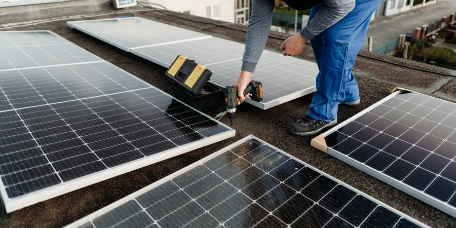 Insinyur teknis memasang sistem panel fotovoltaik surya menggunakan obeng