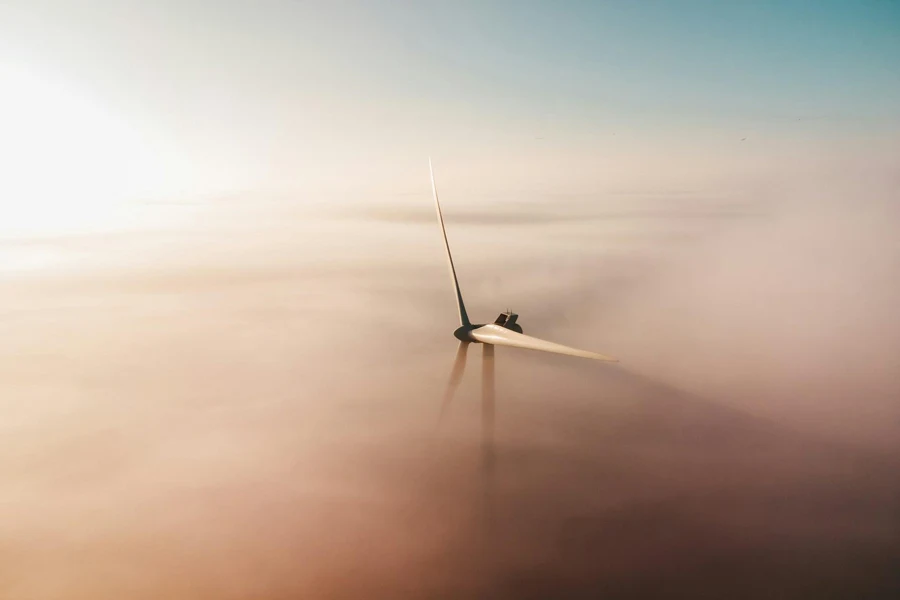 Wind turbine blades emerging through fog
