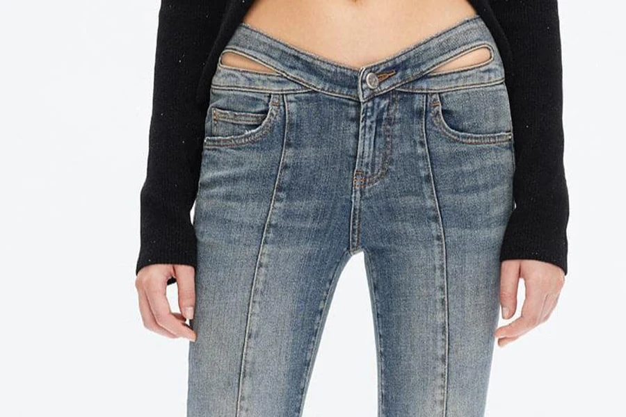 Wanita dengan jeans low-rise dengan detail potongan