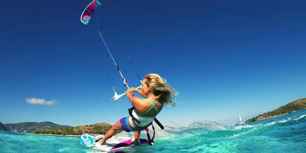 Berrak mavi sularda uçurtma sörfü yapan kadın