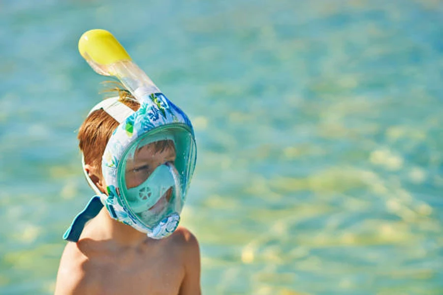 Young boy wearing a light blue full-face snorkeling mask