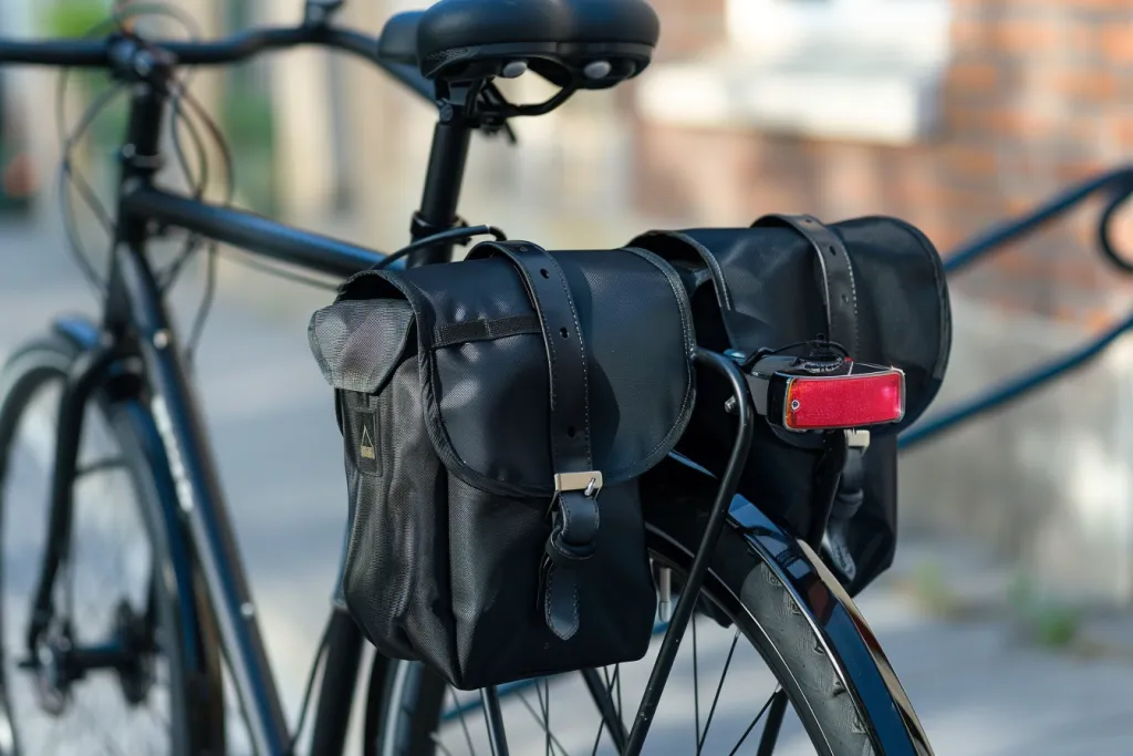 bir yol bisikletinin arkasında iki büyük cepli siyah bisiklet çantası