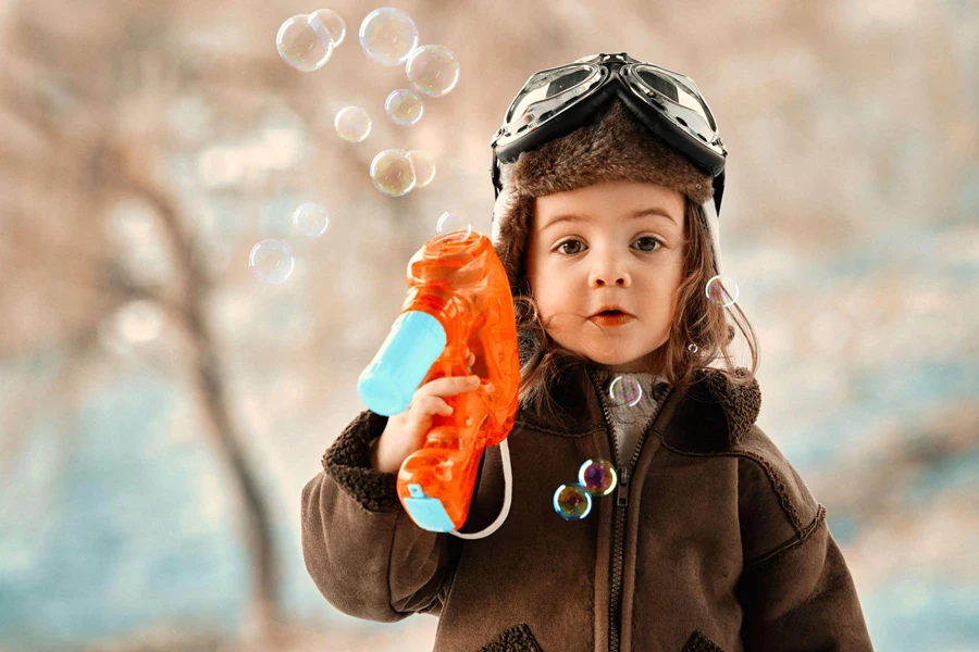 ein süßes Kind mit einer Seifenblasenmaschine