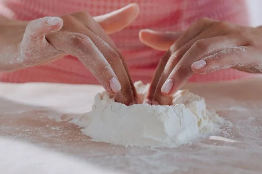 A person preparing dough on a tabletop