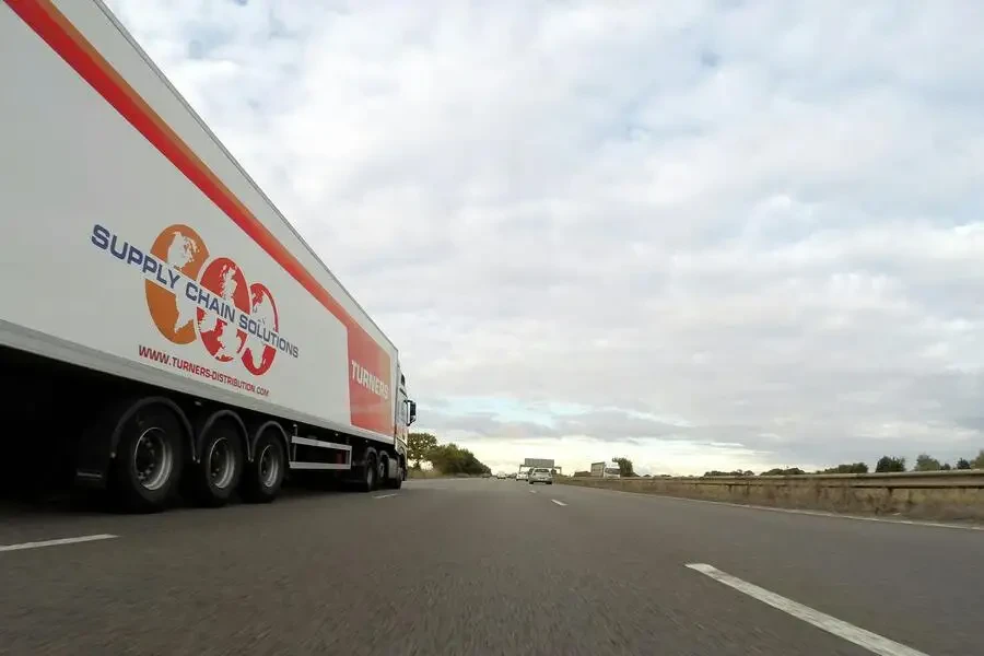 Un camion remorque Turners blanc sur la route